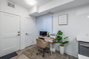 an office with a desk with a computer and a plant at Exquisite 2 Bedroom Apt, mins to the falls. in Niagara Falls