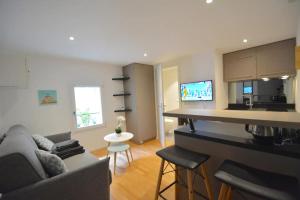 uma cozinha e sala de estar com um sofá e um balcão em Studio Paquier Annecy hyper centre Vieille ville em Annecy