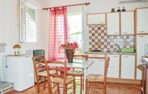 - une cuisine avec une table, des chaises et un évier dans l'établissement Nice Apartment In Zonza With Kitchenette, à Zonza