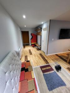 een woonkamer met een bank en een tv bij Casa Magallanes Ushuaia in Ushuaia