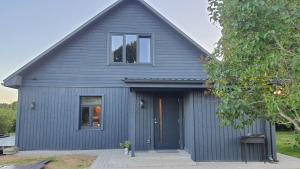 a gray garage with a blue door and a window at Family holiday house near to Baltic sea in Pitrags "JAUNZUMBRI" in Pitragutsiyeme