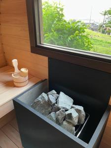 una caja llena de rocas sentada junto a una ventana en 淡路島でサイコーのととのうを体験出来るサウナ宿たんざ二種類のフィンランドサウナを体験できます, en Awaji