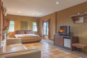 - une chambre avec un lit et une télévision dans l'établissement Muntra Garden Resort, à Sattahip