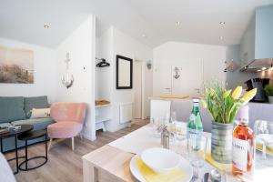 ein Wohnzimmer und eine Küche mit einem Tisch und Stühlen in der Unterkunft Ostseecamp Lübecker Bucht Casa del Mar mit kostenfreier Saunanutzung in Scharbeutz