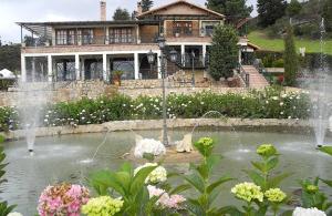 a house with a fountain in front of a pond at Villa Manantial de Sueños - Plan Pareja in Ubaté