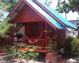 a small wooden house with a blue roof at Coco Garden Resort in Thongsala