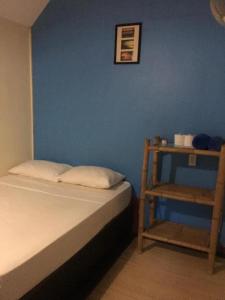 a bedroom with a blue wall and a bed and a chair at Coco Garden Resort in Thongsala