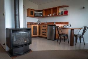 a kitchen with a fireplace and a table with chairs at Eagle View Escape in Rydal