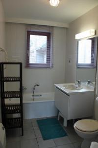 een badkamer met een wastafel, een bad en een toilet bij Duinroos C2 in Koksijde