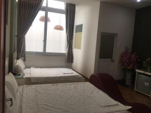 a hospital room with two beds and a window at Melody Homestay Quy Nhơn in Quy Nhon