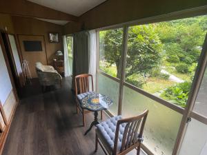 a room with two chairs and a table and a window at 淡路島 サウナ宿たんざ in Awaji