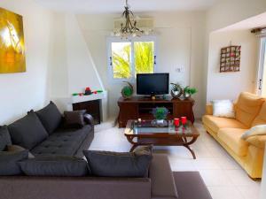 een woonkamer met een bank en een tafel bij Beach Villa Sea View, XXL Pool, 4 Bedroom in Ayia Napa