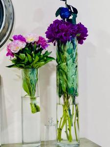 two vases with flowers in them on a table at Grand Fortune Hotel in Yerevan