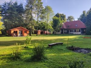 a house in the middle of a yard with a house at Domek mazurski ze świerka syberyjskiego. in Zdory