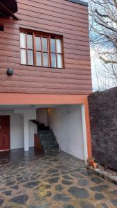 a house with a staircase in front of it at CASA los ciruelos in El Bolsón