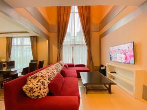 een woonkamer met een rode bank en een tafel bij Twenty Two Pool Villa in Pattaya