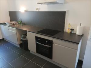 a kitchen with a stove and a counter top at O'Couvent - Appartement 524 - 5 chambres - 125 m2 - Deuxième étage in Salins-les-Bains