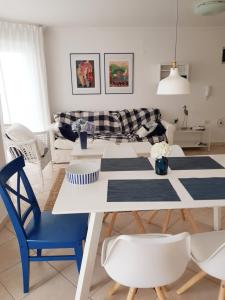 a living room with a white table and blue chairs at Apartment with a sea view in Skiper resort in Crveni Vrh