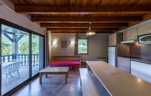 a kitchen with a table and a living room at Résidence Les Trois Vallées - ARREAU in Arreau