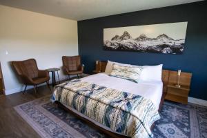 a bedroom with a bed and two chairs at Teton Peaks Resort in Tetonia