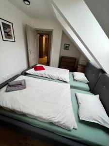 1 dormitorio con 2 camas con sábanas blancas en Apartmán JUH, en Tale