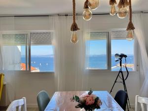 a table with a bouquet of flowers and a camera at Playa y ciudad. in Ribeira
