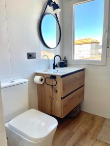 a bathroom with a sink and a toilet and a mirror at Playa y ciudad. in Ribeira +24 photos