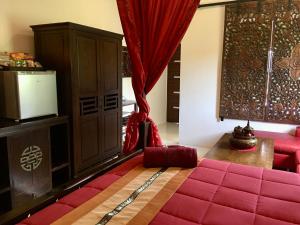 a room with a red bed and a red couch at Naraya Homestay in San Pa Tong