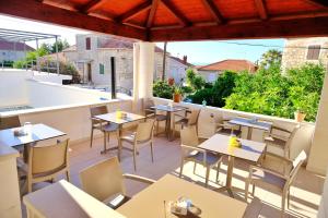 a restaurant with tables and chairs on a balcony at Boutique Hotel Alegria in Supetar