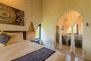 a bedroom with a bed and a bathroom with a sink at Flow House 3BR Beachfront An Bang Beach Hoi An by Beachside Boutique Homes in An Bàn (2)