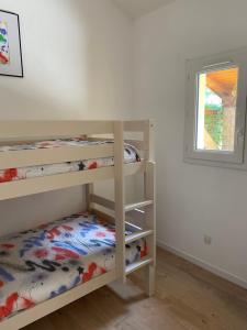een slaapkamer met 2 stapelbedden en een raam bij Le petit Atelier in Eyguières