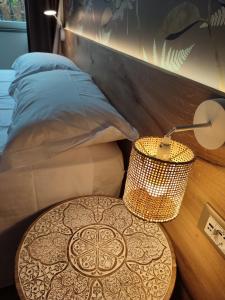 eine Lampe auf einem Tisch neben einem Bett in der Unterkunft Le stanze di Diana in Cesenatico