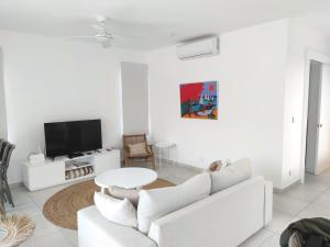 uma sala de estar branca com um sofá branco e uma mesa em Appartement neuf à Trou aux Biches em Trou-aux-Biches