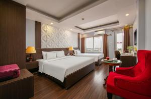 a hotel room with two beds and a red chair at Hanoi Diamond King Hotel & Travel in Hanoi