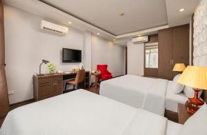 a hotel room with two beds and a desk at Hanoi Diamond King Hotel & Travel in Hanoi