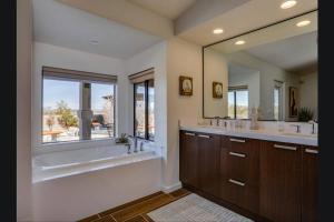 a bathroom with two sinks and a tub and a window at Breathtaking Roadrunner Heights in Joshua Tree