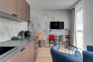 kuchnia z niebieskimi krzesłami i telewizorem na ścianie w obiekcie City Center Garden Gates Boutique by Downtown Apartments w Gdańsku