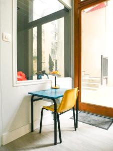 una mesa, una silla y una lámpara en una ventana en Bordeaux centre historique: Charmant Duplex en Burdeos
