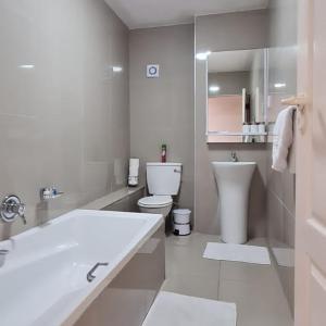 bagno bianco con lavandino e servizi igienici di Cascades 103 a Port Elizabeth