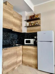 a kitchen with wooden cabinets and a white refrigerator at Dream Apartment Tsaghkadzor in Tsaghkadzor