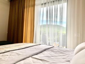 a bedroom with a bed and a large window at Dream Apartment Tsaghkadzor in Tsaghkadzor