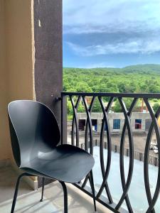 a black chair sitting on a balcony with a view at Dream Apartment Tsaghkadzor in Tsaghkadzor