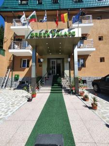 ein Gebäude mit grünem Rasen davor in der Unterkunft Hotel Green Palace in Sinaia