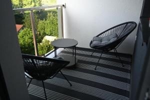 2 sillas y una mesa en el balcón en Apartman Mosaic, en Doboj