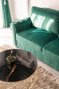 a living room with a green couch and a coffee table at Toto’s Apartment in Constanţa