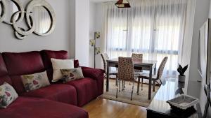 a living room with a red couch and a table at En Ribeira para 4 céntrico con parking in Ribeira