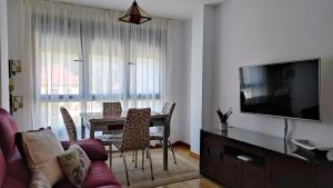 ein Wohnzimmer mit einem Esstisch und einem TV in der Unterkunft En Ribeira para 4 céntrico con parking in Ribeira