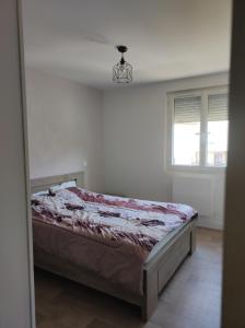 a bedroom with a bed in a white room at Appartement Mont Guillaume in Embrun