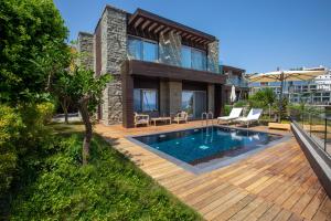 a house with a swimming pool and a wooden deck at METT Hotel & Beach Resort Bodrum in Bodrum City
