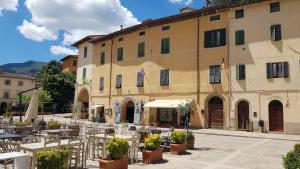 un edificio con tavoli e sedie di fronte ad esso di La Mansarda di Marilyn in Toscana a Cetona